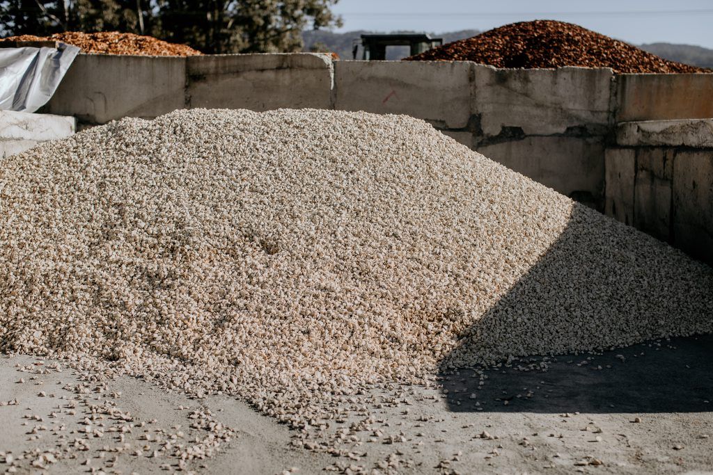 A Pile of Gravel is Sitting Next to a Pile of Wood Chips — Bonville Landscape Centre in Urunga, NSW