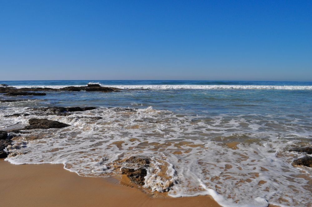 A Beach With Waves Crashing Against the Rocks on a Sunny Day — Bonville Landscape Centre in Valla Beach, NSW