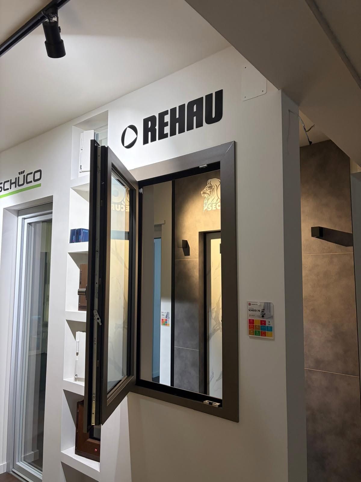 Vetrina dello showroom REHAU con una finestra a battente aperta e cartelli dei prodotti