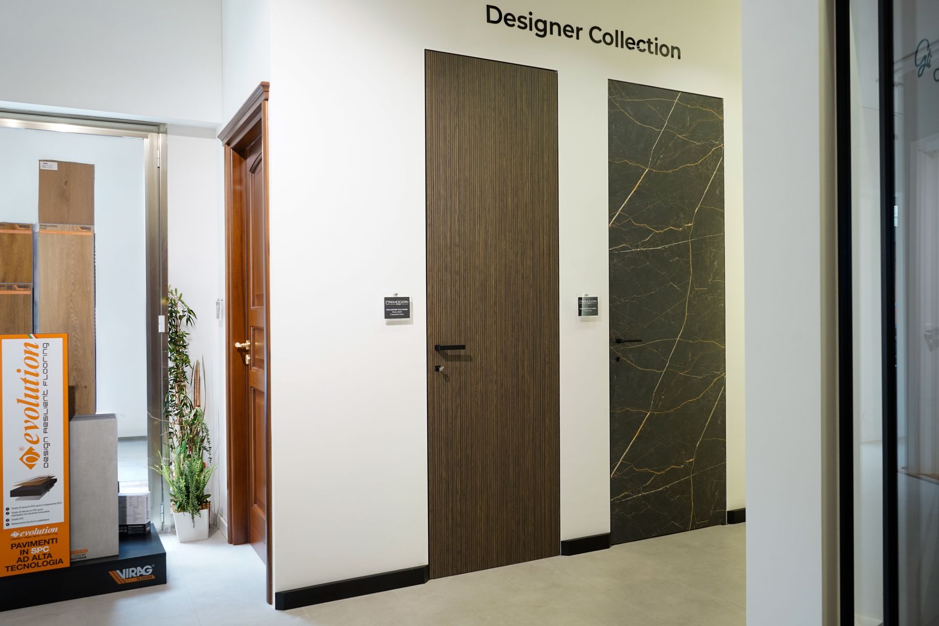 Corridoio con due porte di design e un cartello a parete, che mostra un allestimento d’interni moderno.
