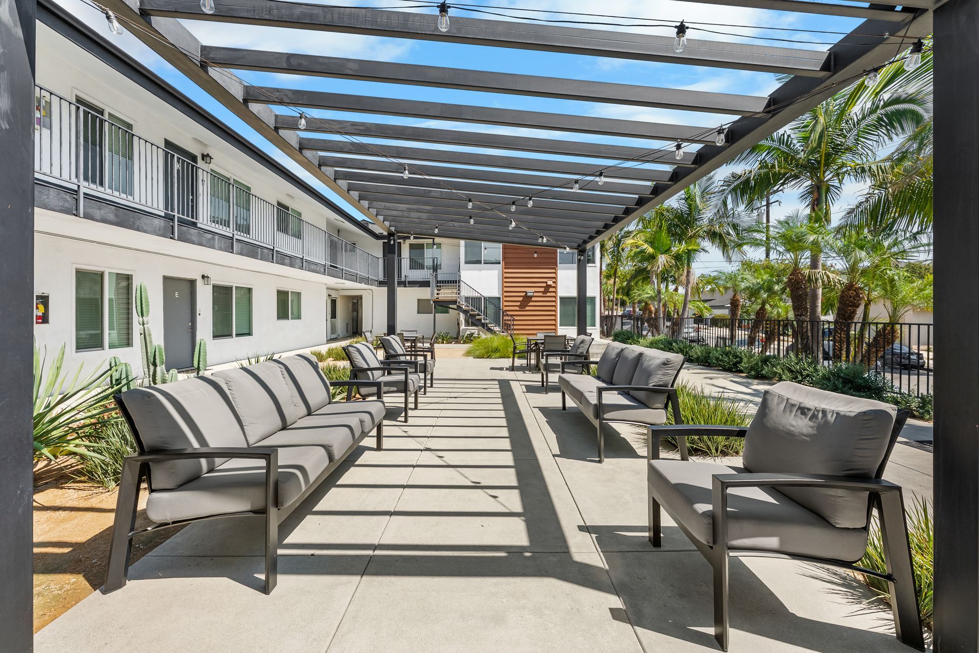 courtyard with awning, BBQ grills, couches, and tables