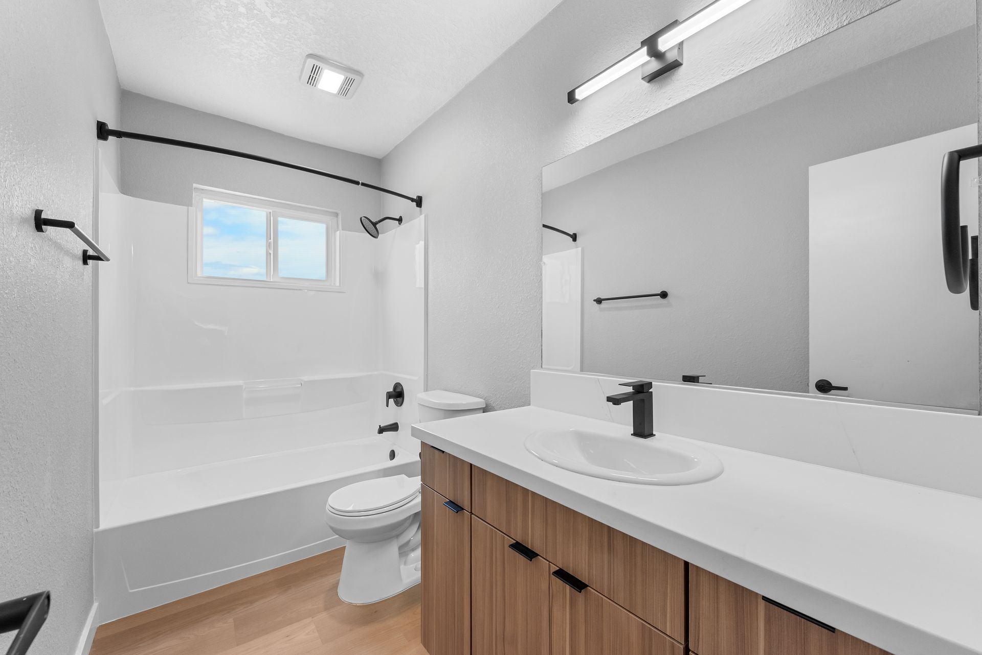 apartment restroom with sink, toilet, and shower