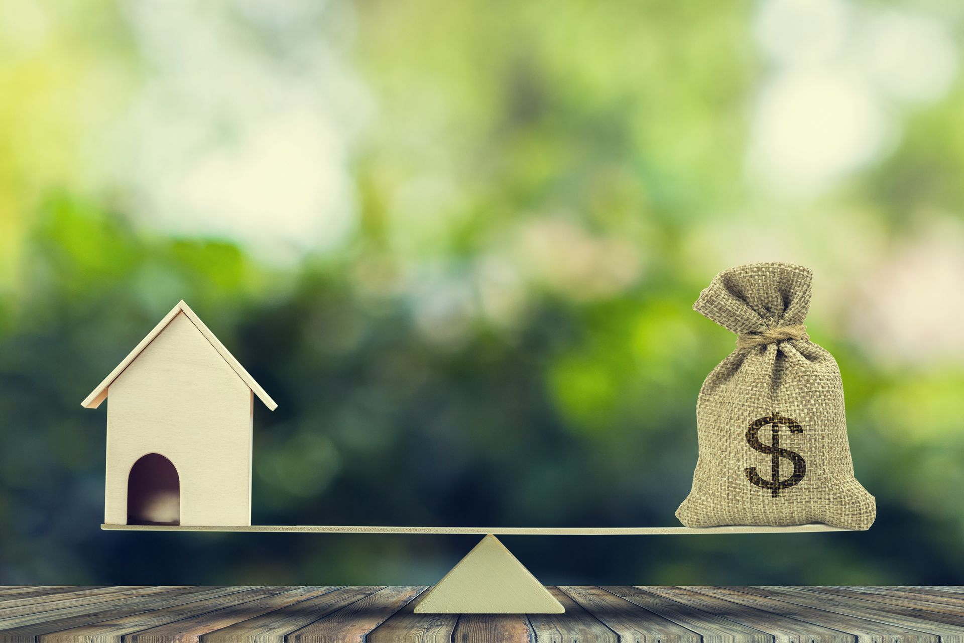 Depiction of a home and money in a balance depicting the refinance process.