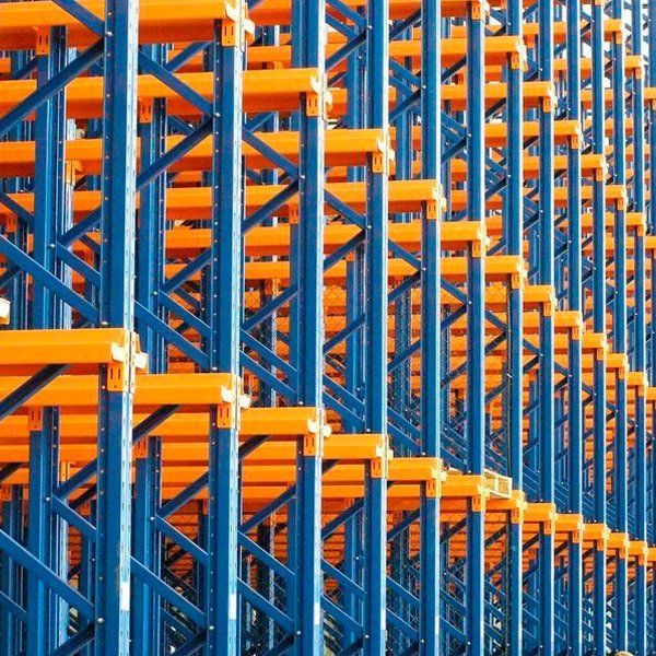 Una fila de estantes azules y naranjas en un almacén.
