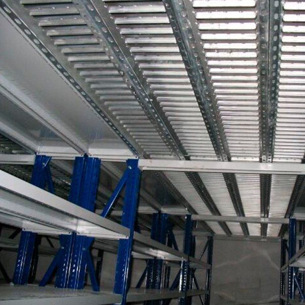 Un almacén con estantes azules y techo de metal.