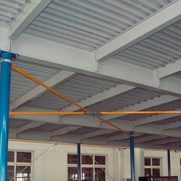Una gran sala con techo blanco y postes azules.