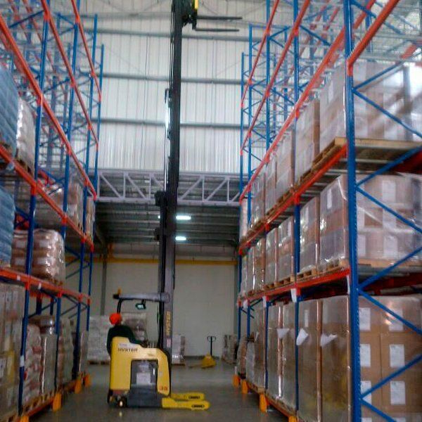 Un almacén lleno de muchas cajas y una carretilla elevadora