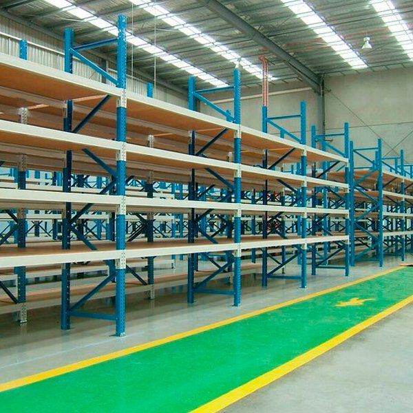 Un almacén con muchas estanterías y suelo verde.