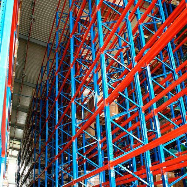 Un almacén con estantes azules y rojos llenos de cajas.