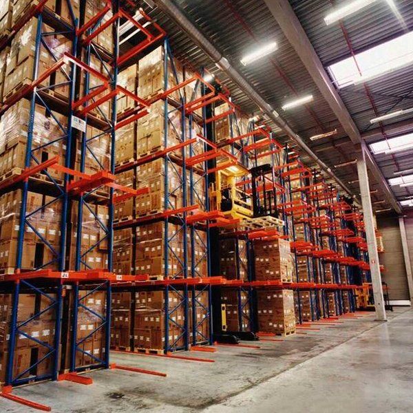 Un almacén lleno de muchas cajas y una carretilla elevadora