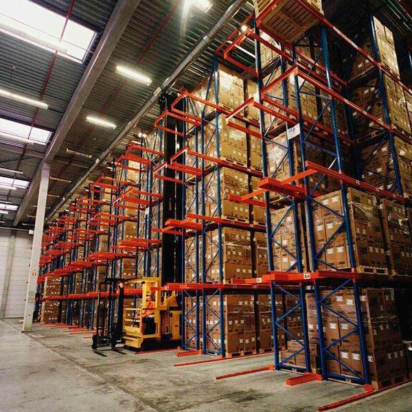 Un almacén lleno de muchas cajas y una carretilla elevadora