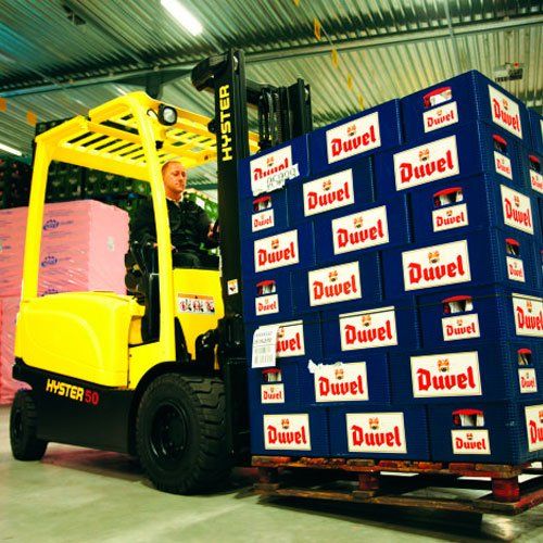 Una carretilla elevadora transporta un palé de cajas duvel.