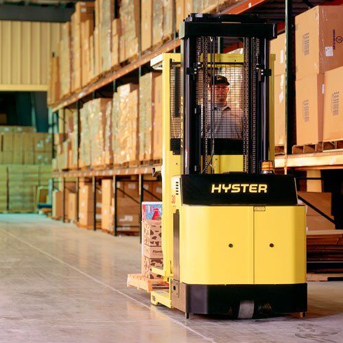 Una carretilla elevadora Hyster amarilla está estacionada en un almacén