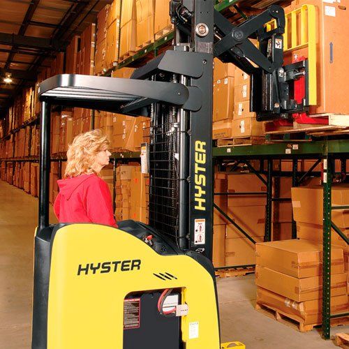 Una mujer conduce una carretilla elevadora Hyster en un almacén.