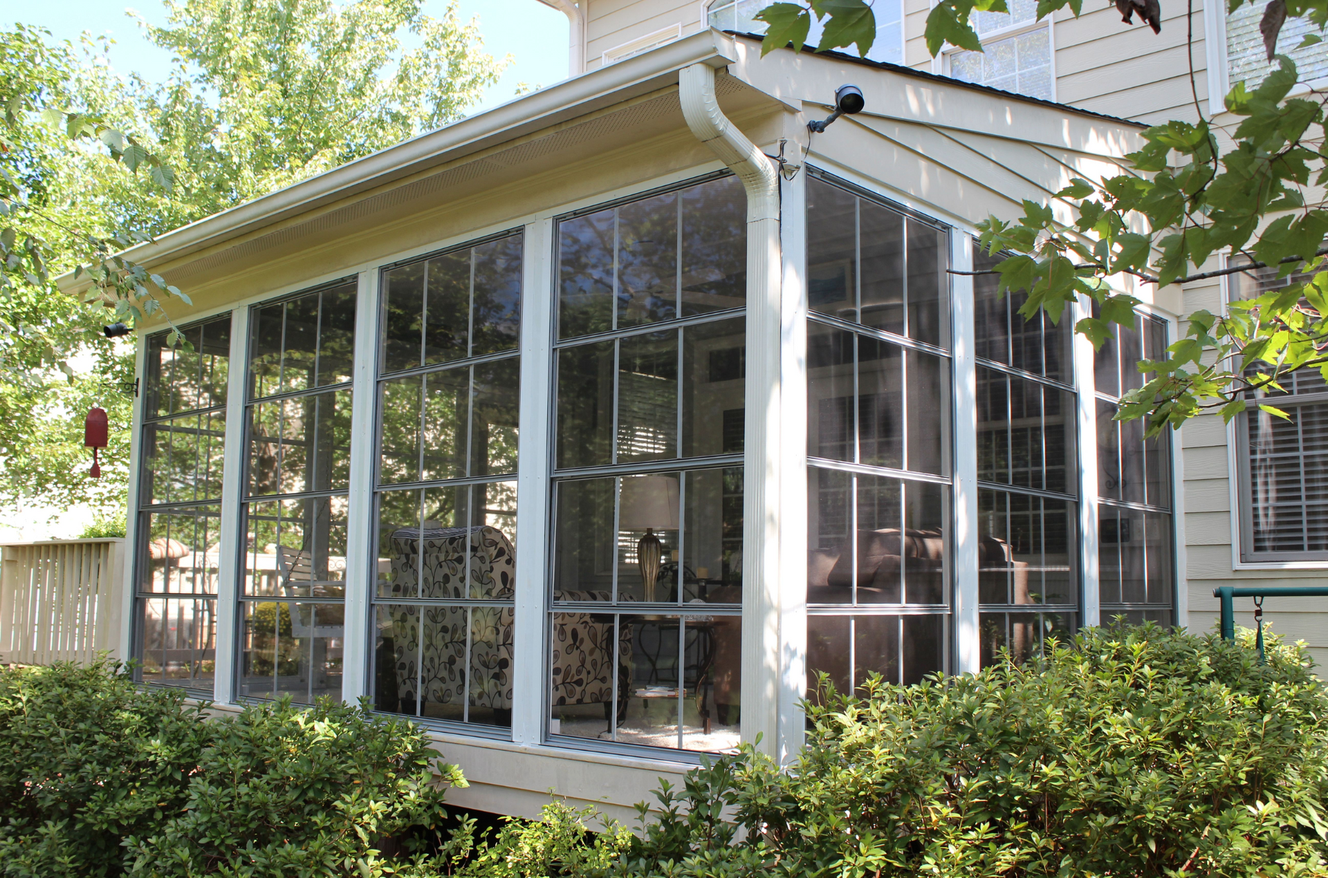 A screened in porch on the side of a house