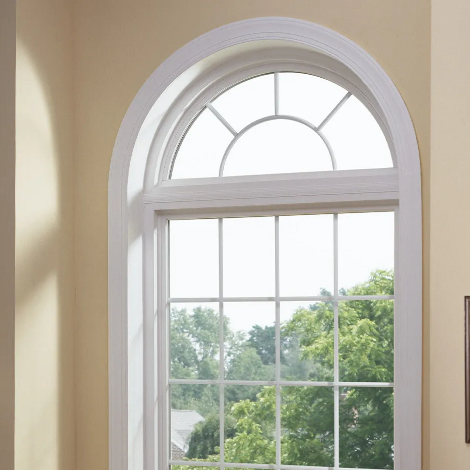 A large arched window with a picture on the wall behind it