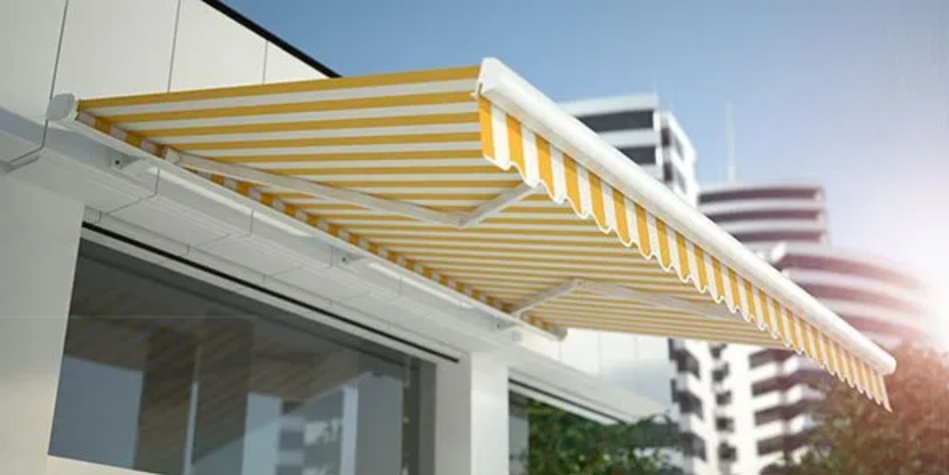 A yellow and white awning is on the side of a building.