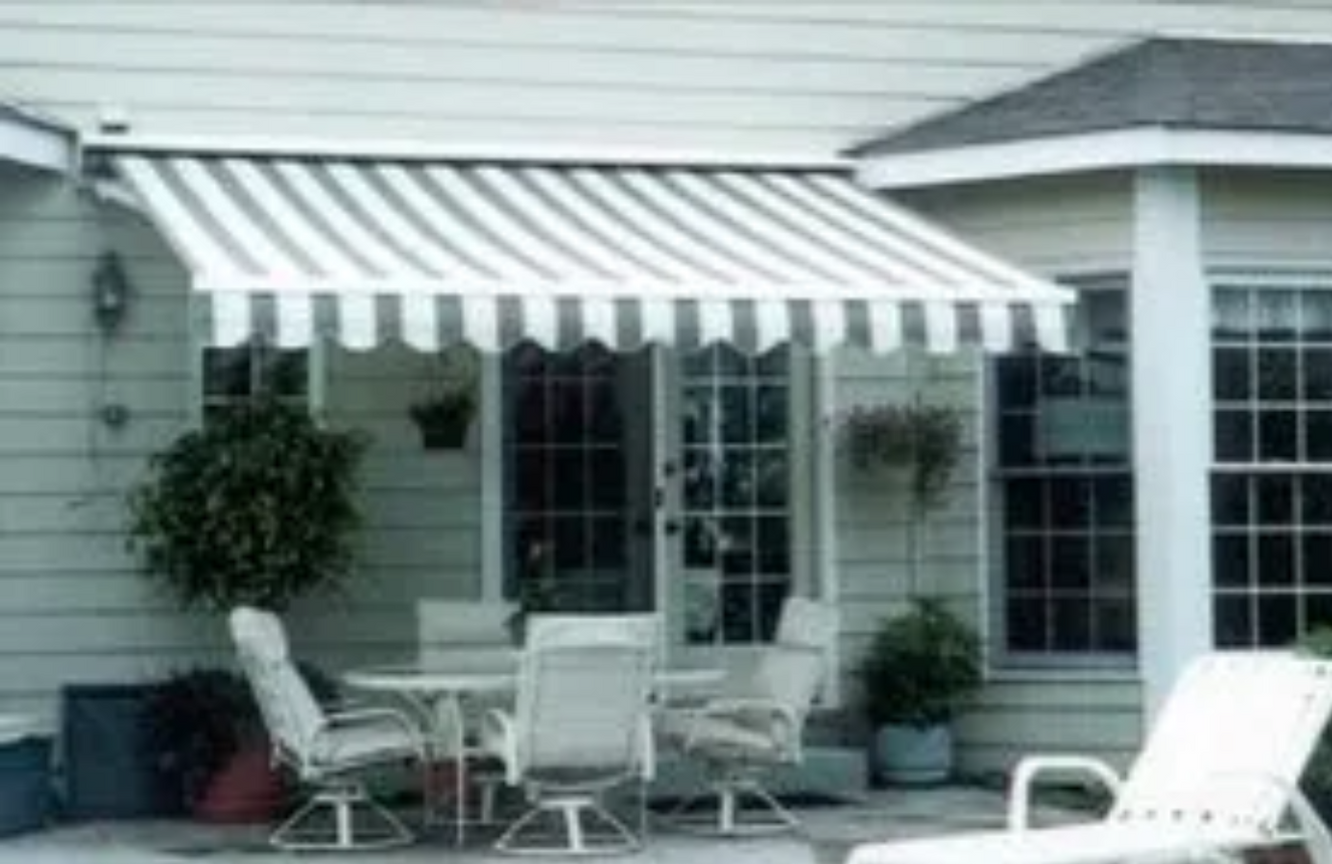A white awning over a patio with a table and chairs