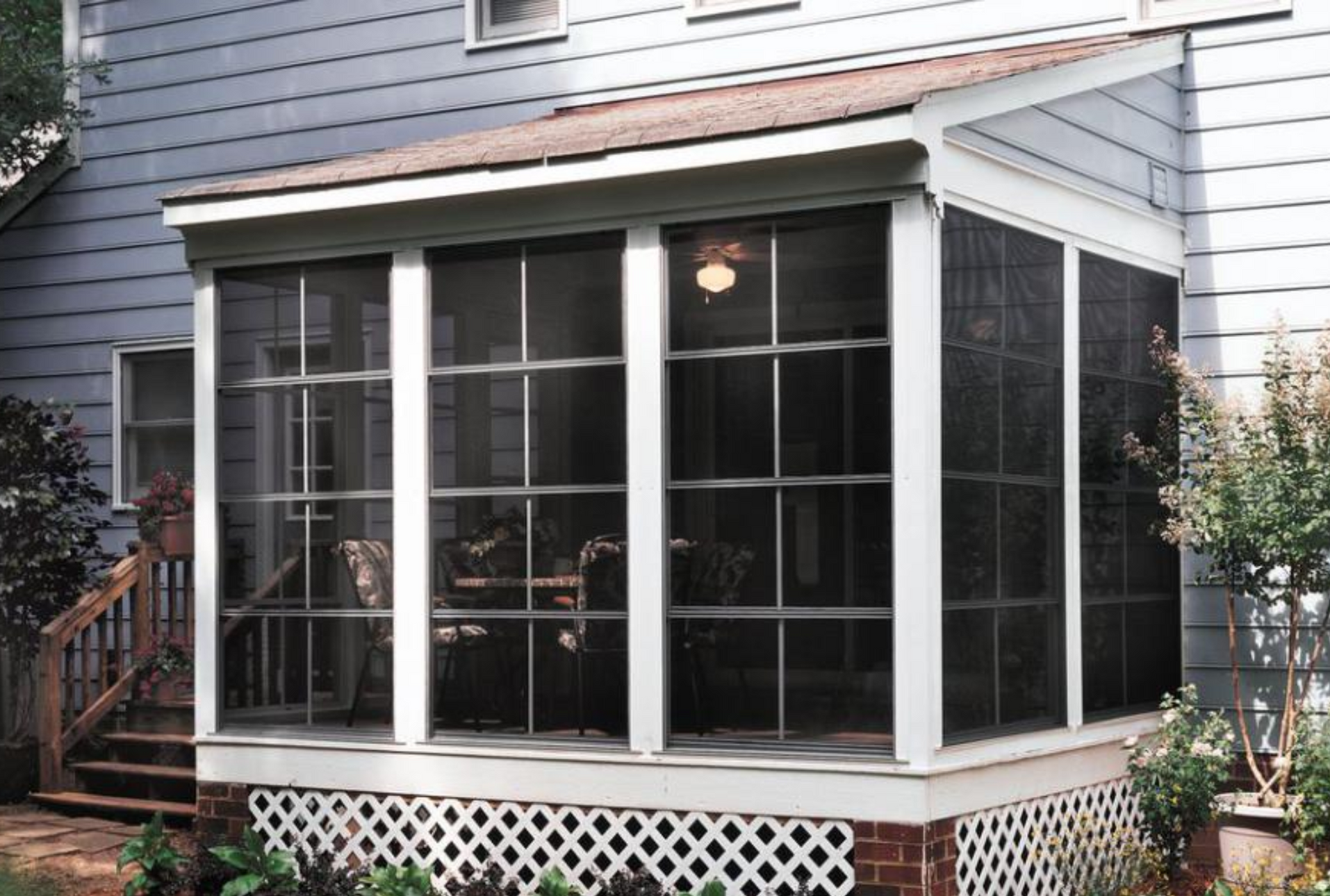 A screened in porch on the side of a house