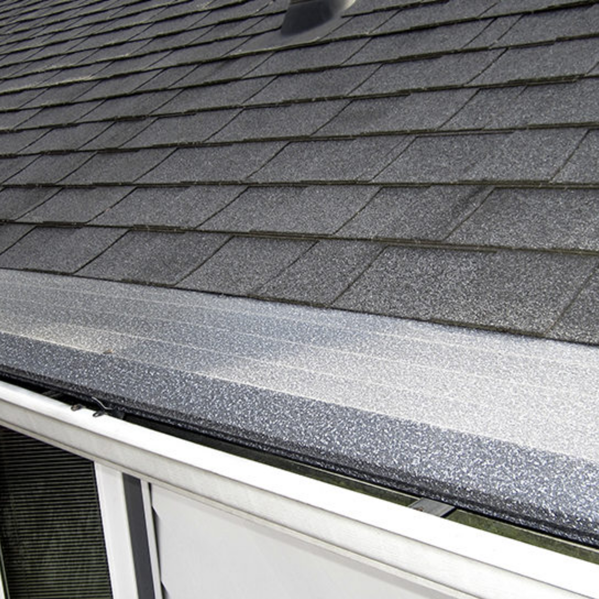 A close up of a roof with shingles and a gutter