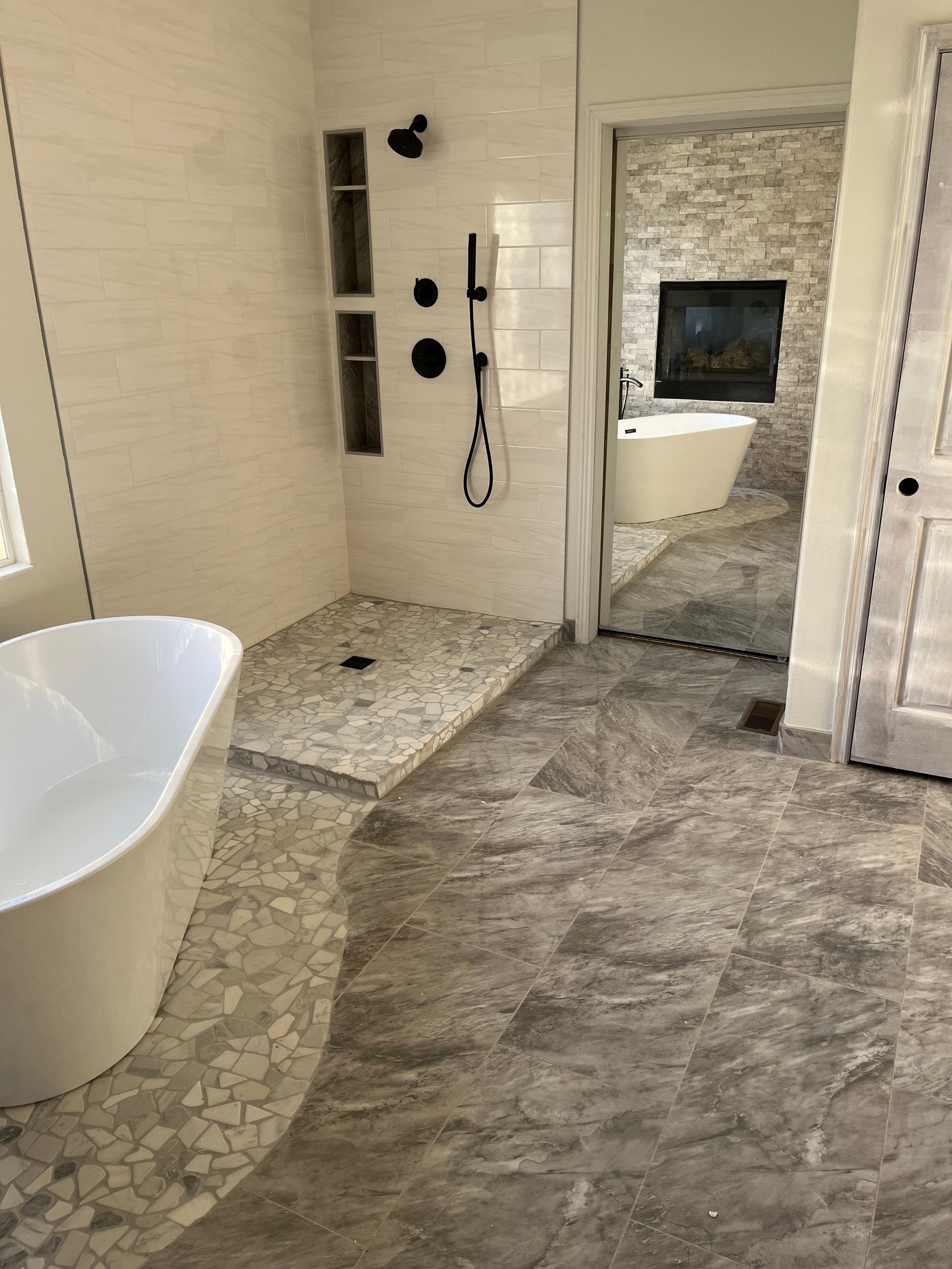 Modern bathroom with freestanding tub, tiled shower, and large mirror
