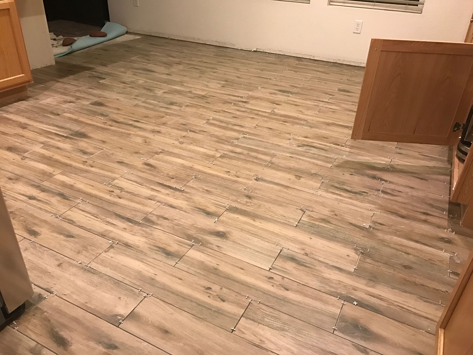 Empty room with wood-patterned flooring and open cabinet doors on both sides