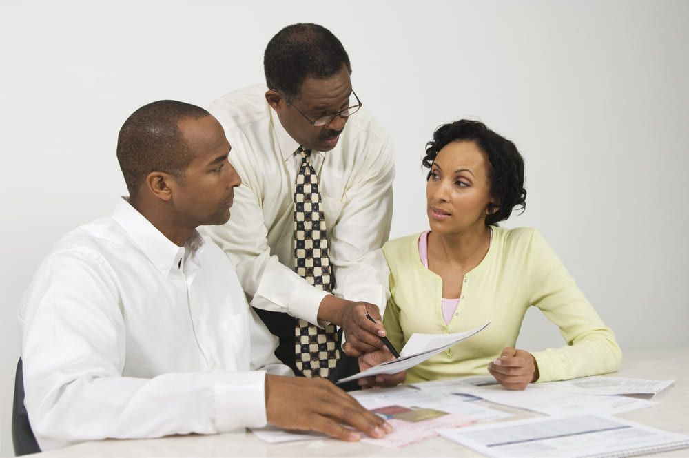 A group of people are sitting at a table looking at papers.