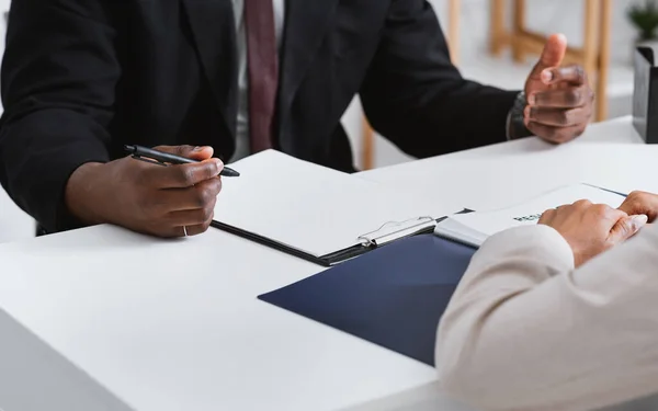 A man and a woman are sitting at a table having a conversation.