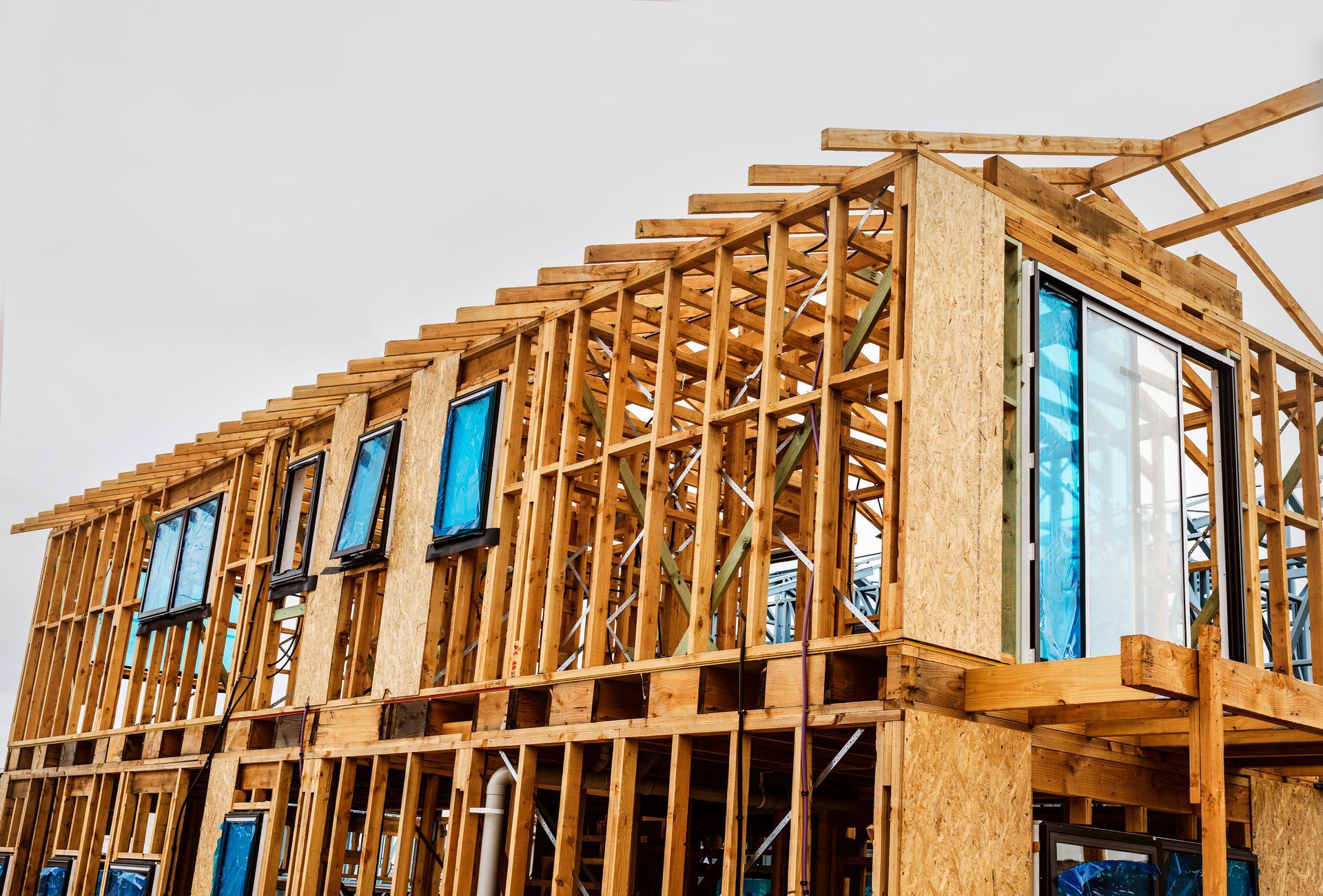 New timber truss frame of a house under construction at a housing development site.