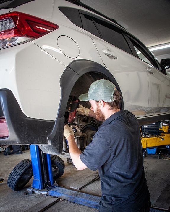 White Cars lifted up in Garage | BJ’s Automotive Diagnostic Center