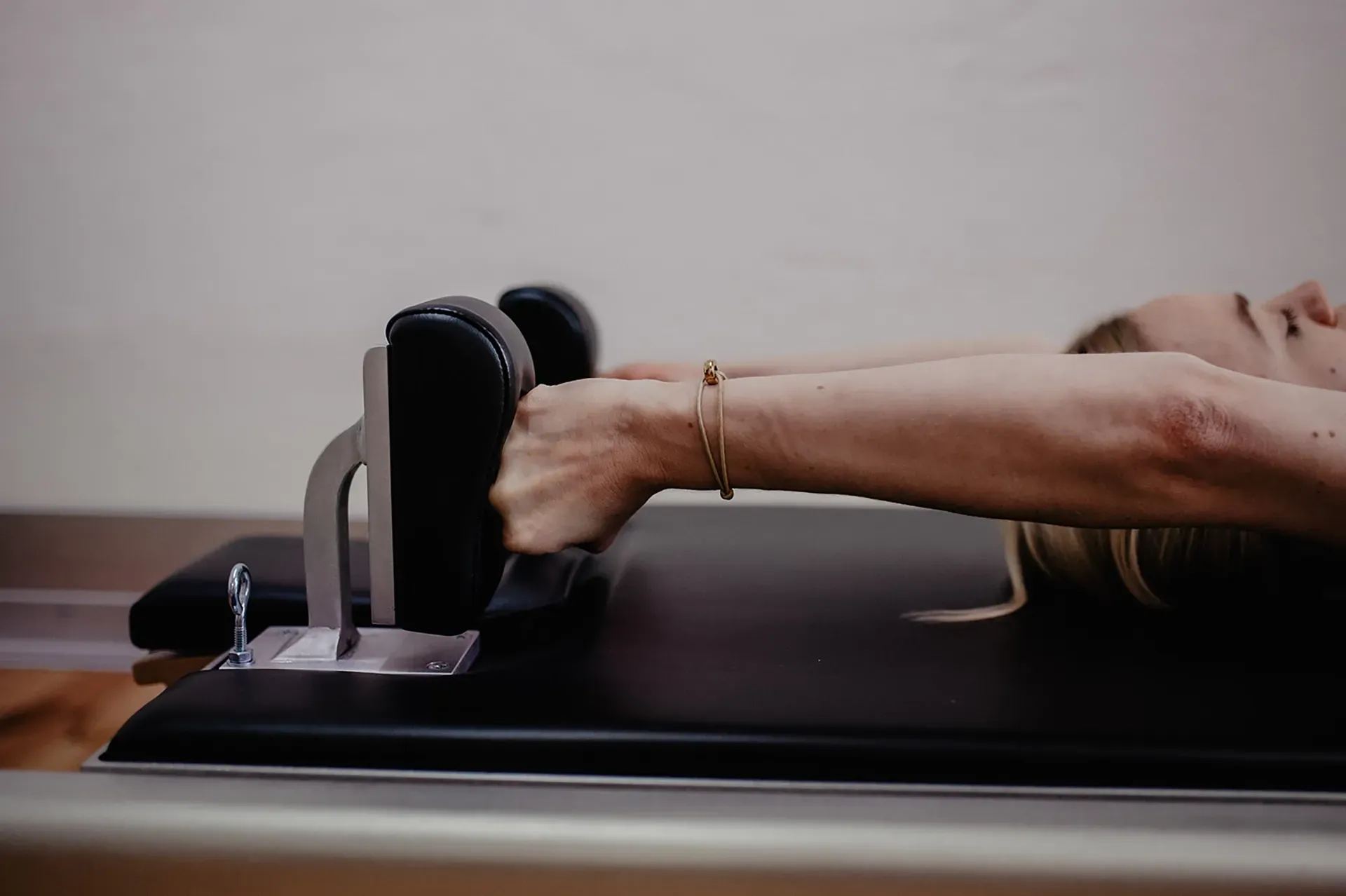 Person, die sich in einem Studio auf einem Pilates-Reformer dehnt