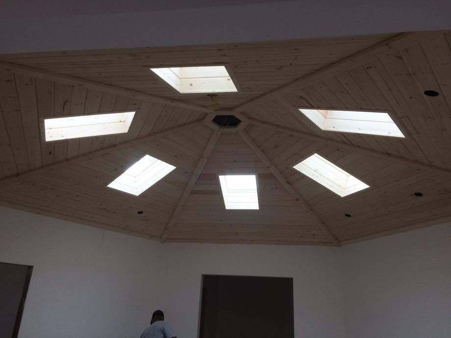Octagonal ceiling with skylights and a central vent above a room doorway
