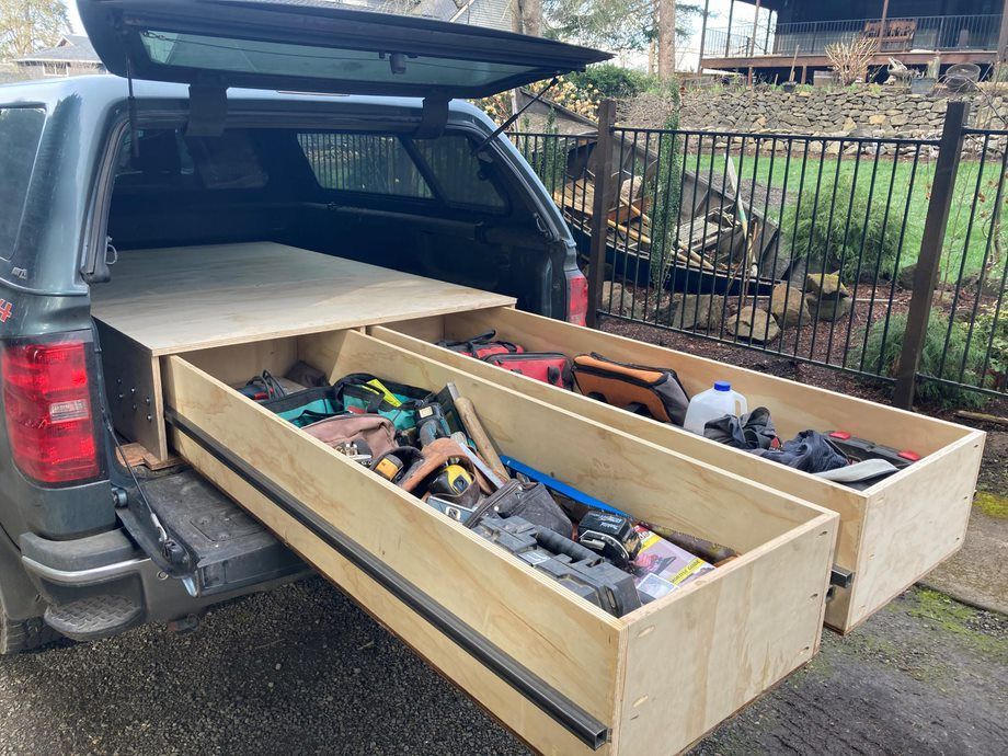 SUV with open hatch and custom wooden storage drawers filled with tools and supplies