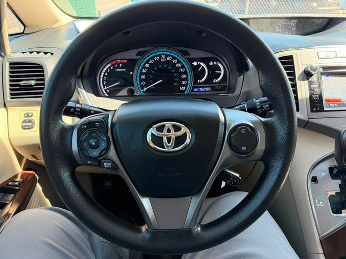 Toyota car steering wheel and dashboard viewed from the driver’s seat, with center console visible.