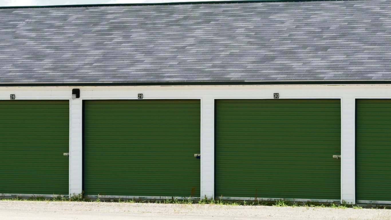 Gravel lot with blue metal storage units under a bright sky
