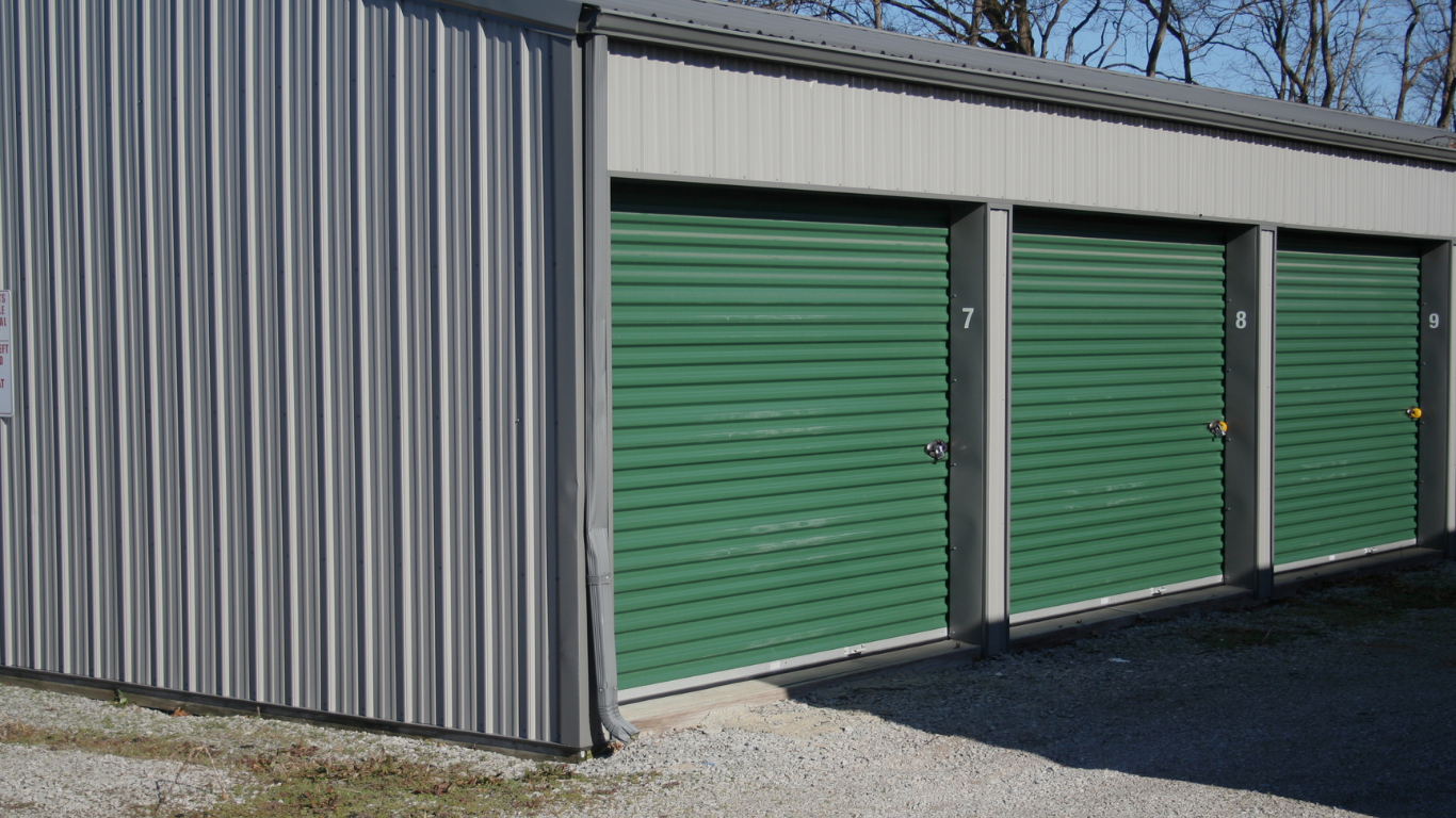 Long row of blue storage unit doors in a clean, bright indoor hallway