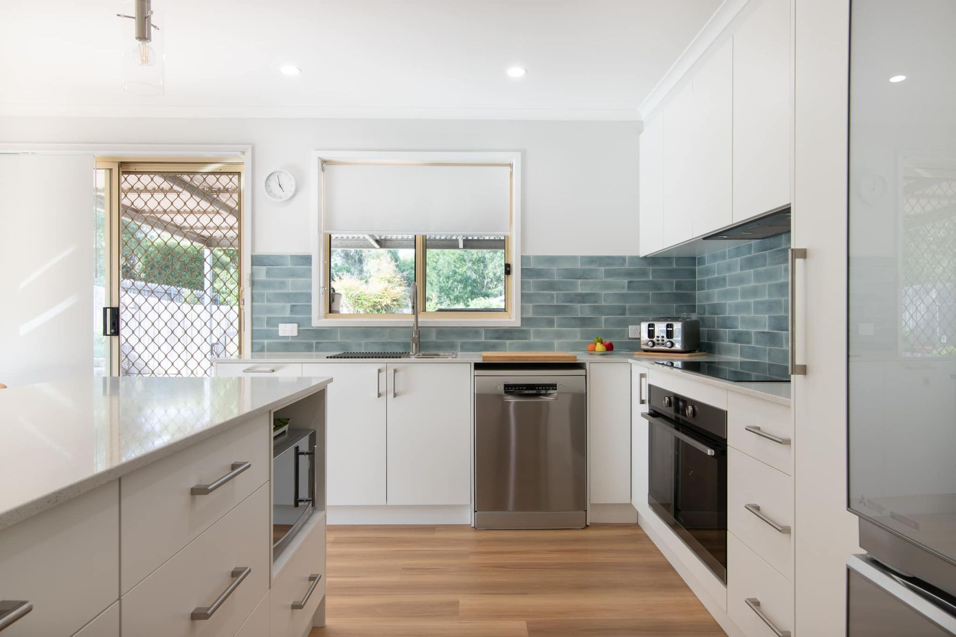 A kitchen with white cabinets and stainless steel appliances.