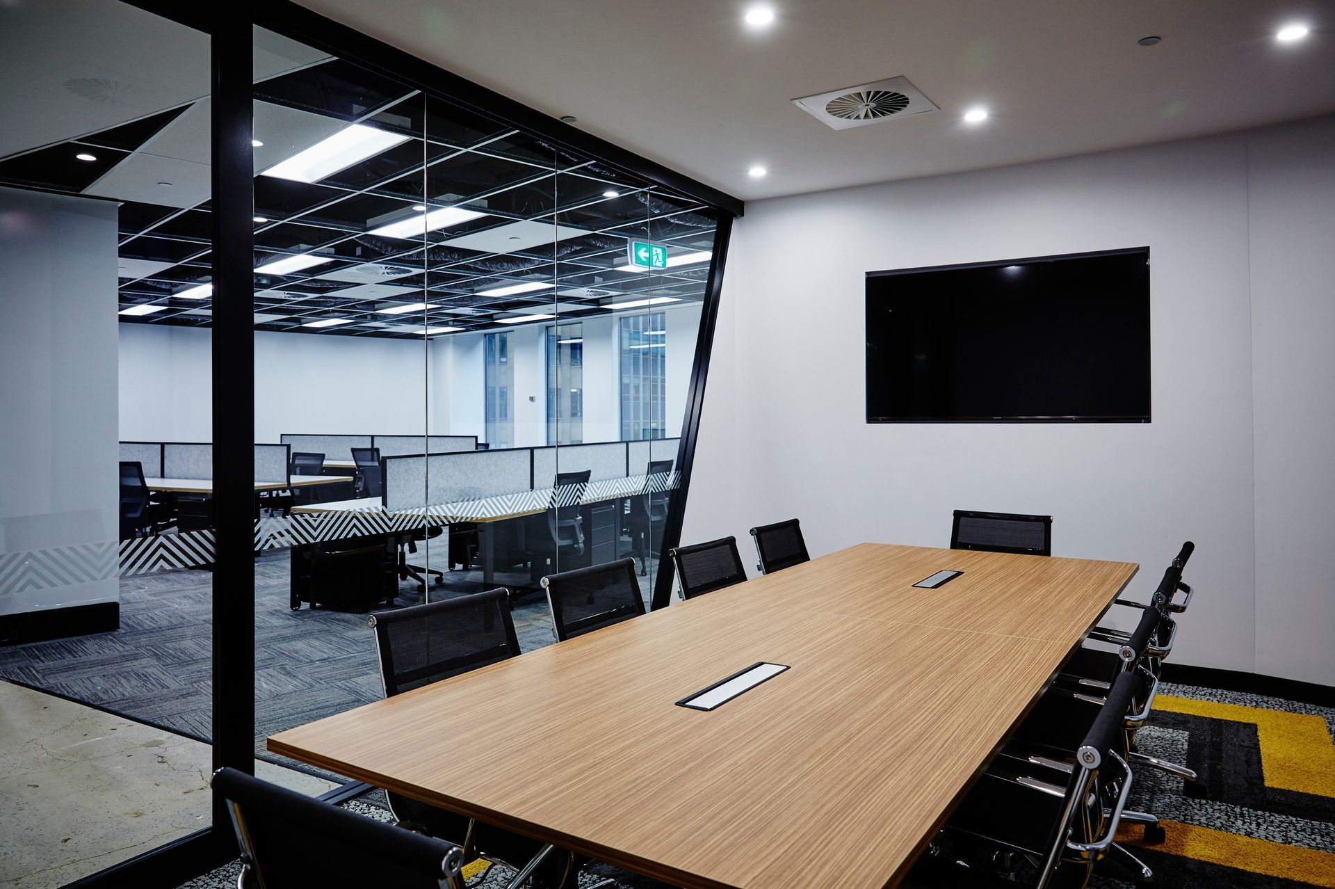 A conference room with a long wooden table and chairs.