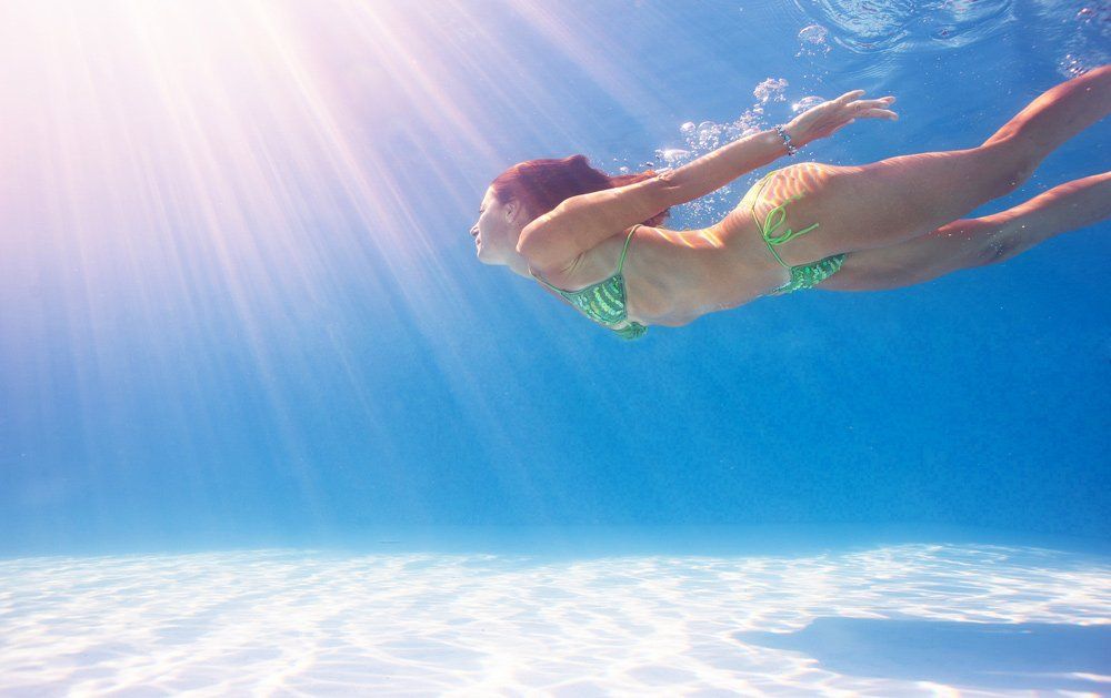 Woman Swimming Underwater — Quality Swimming Pools in Coolangatta, QLD