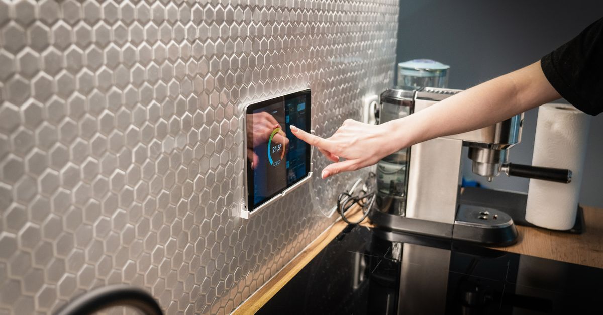 Person using a tablet to control smart home lighting, audio, and climate systems