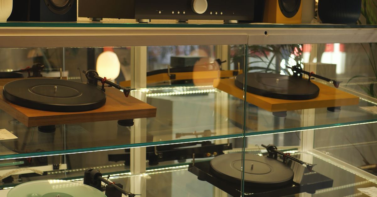 Audio listening event in a showroom with high-end speakers and warm ambient lighting
