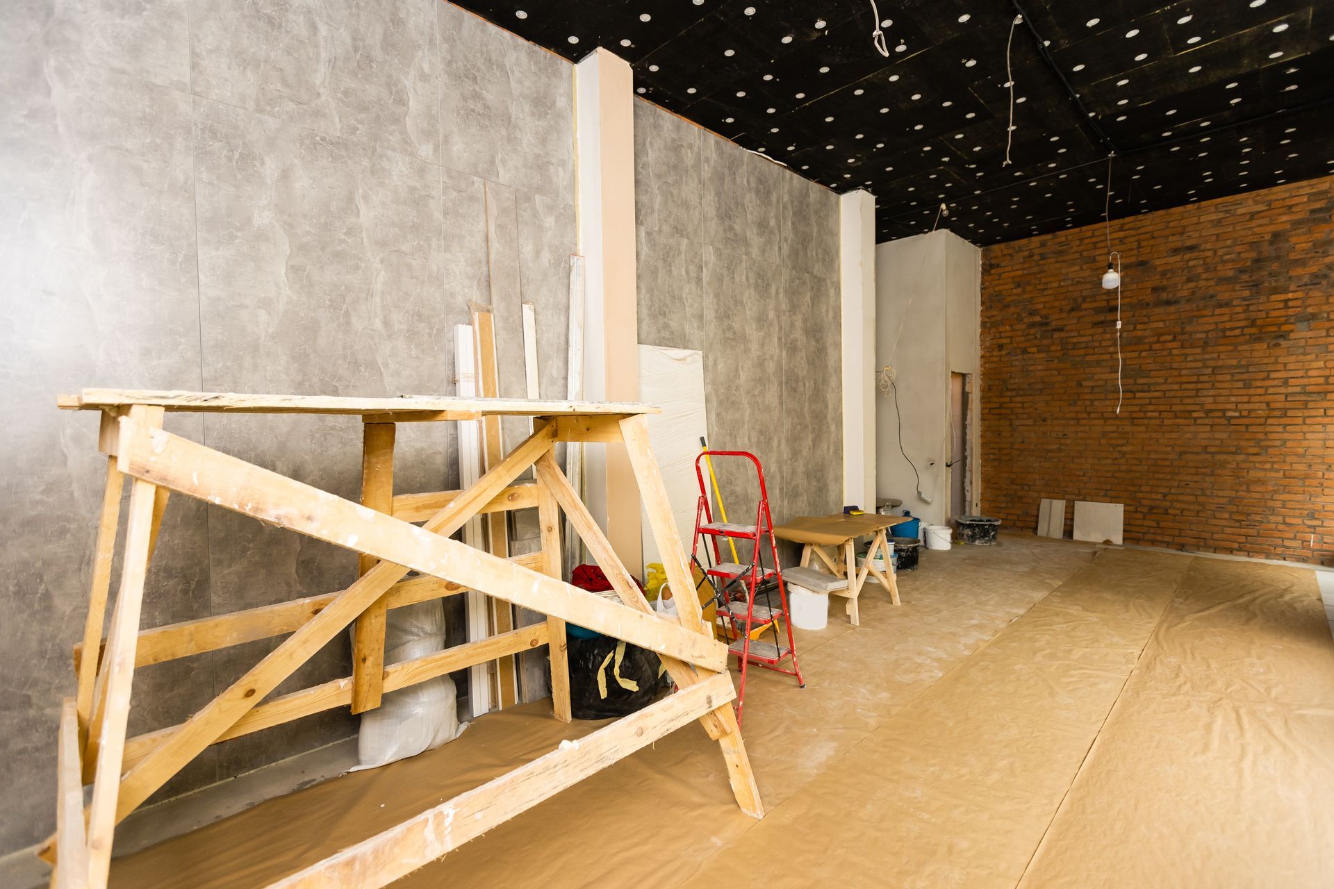 A room under construction with wooden scaffolding and a ladder.