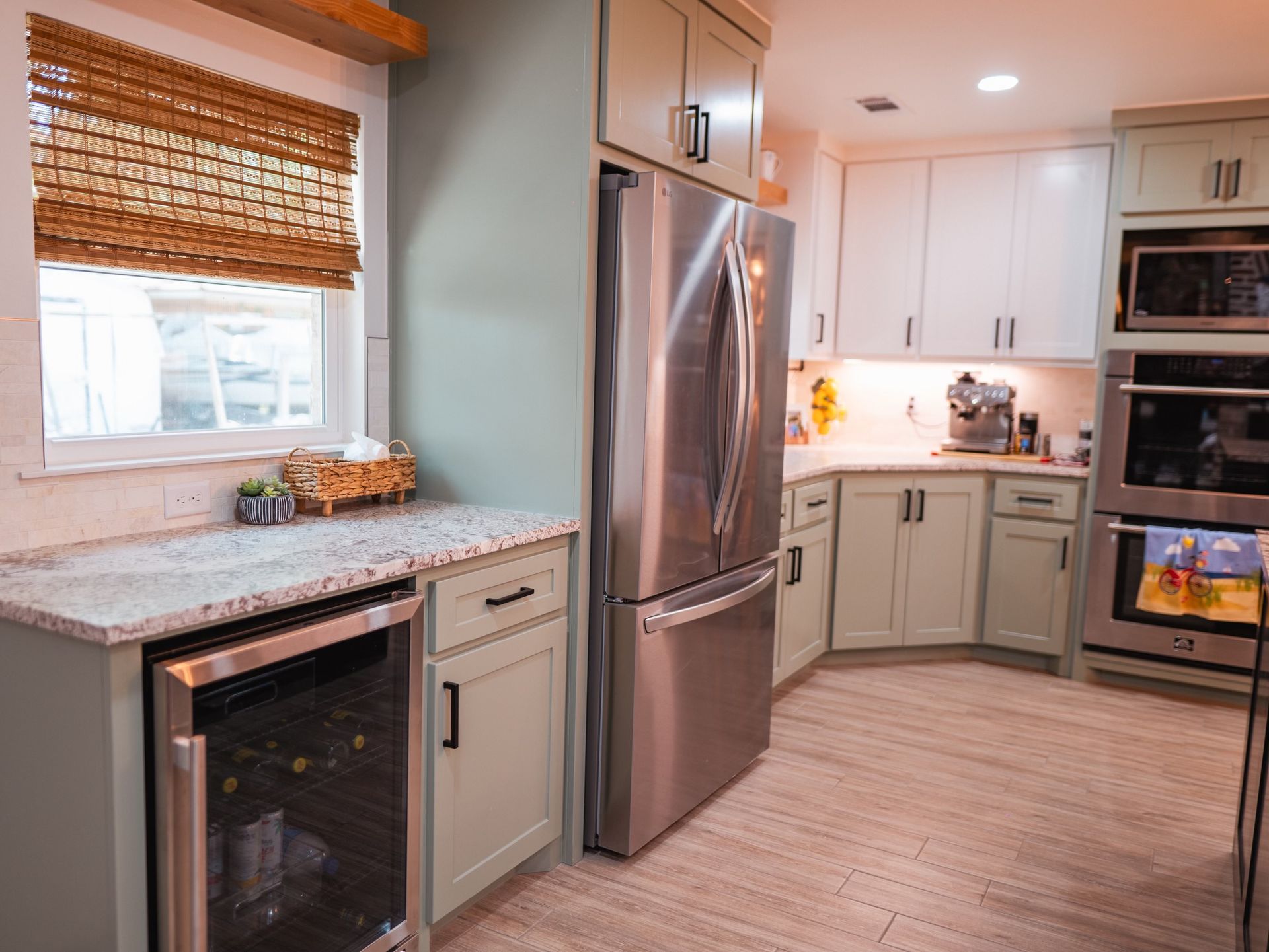 A kitchen with stainless steel appliances and white cabinets.