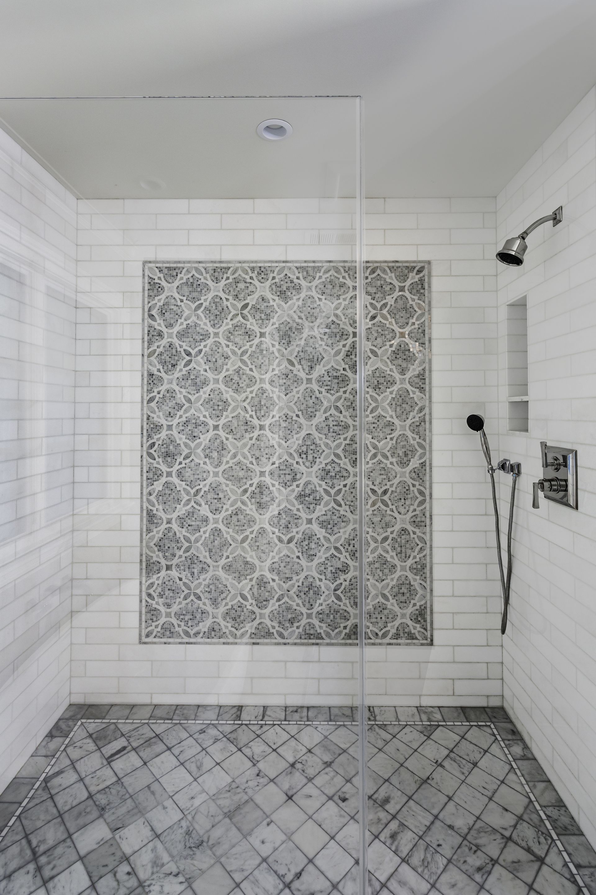 A bathroom with a walk in shower and a sink.