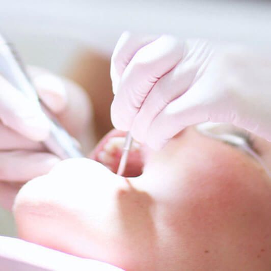 a close up of a person getting their teeth examined by a dentist .