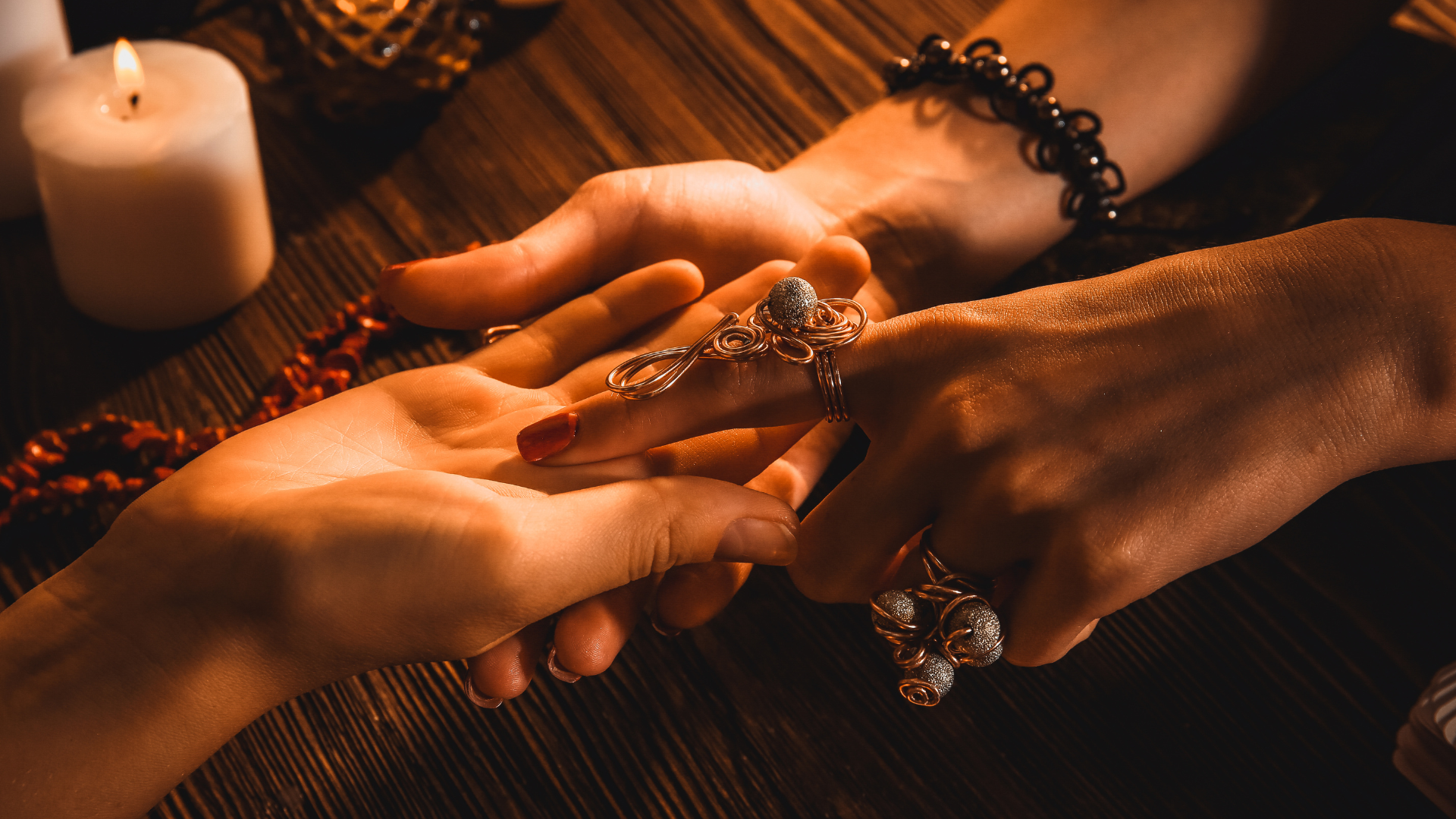 A woman is holding another woman 's hand and reading her palm.