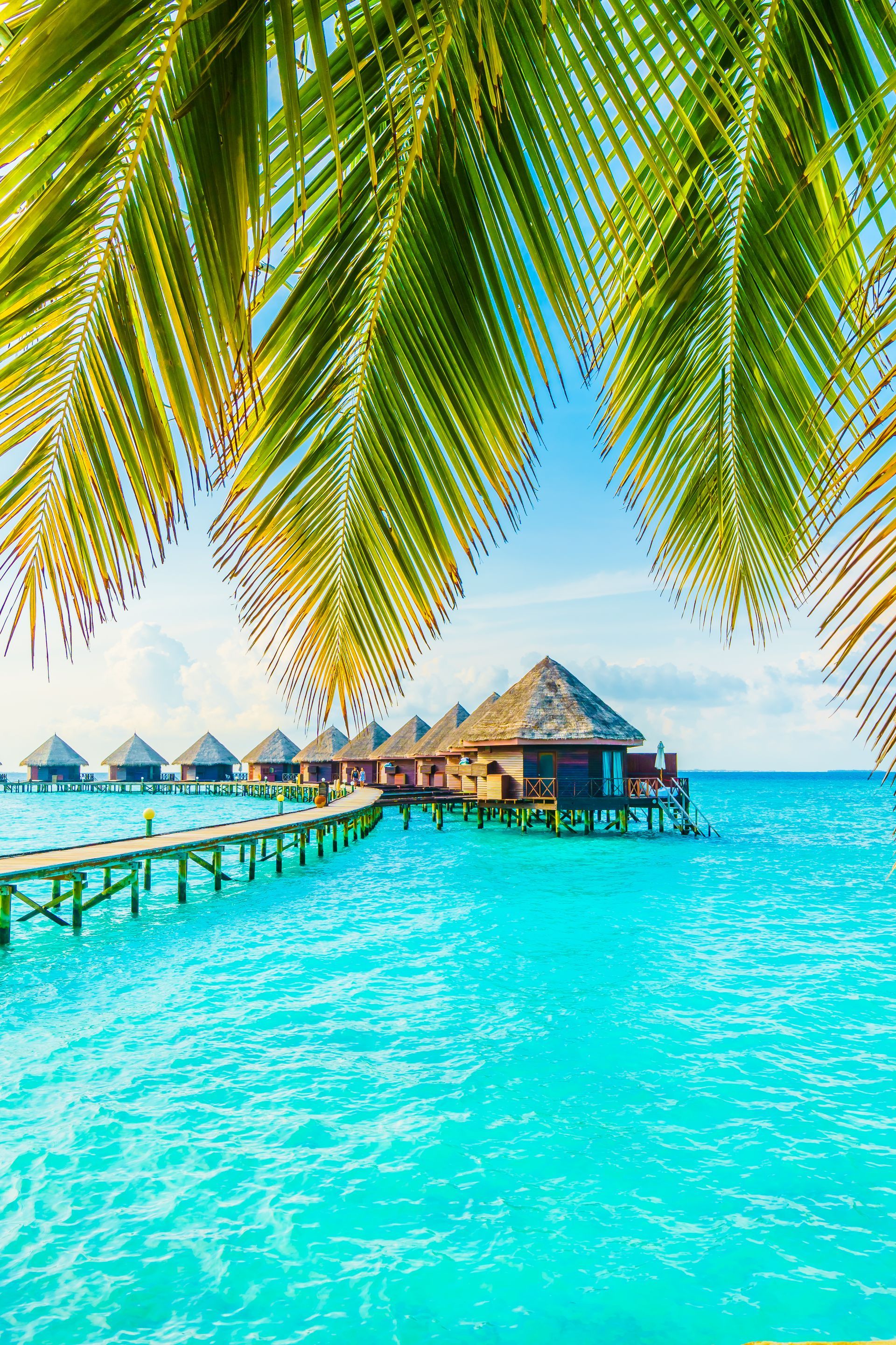 A row of bungalows on stilts in the middle of the ocean.