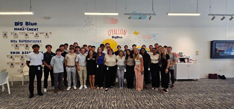 A large group of people are posing for a picture in a room.