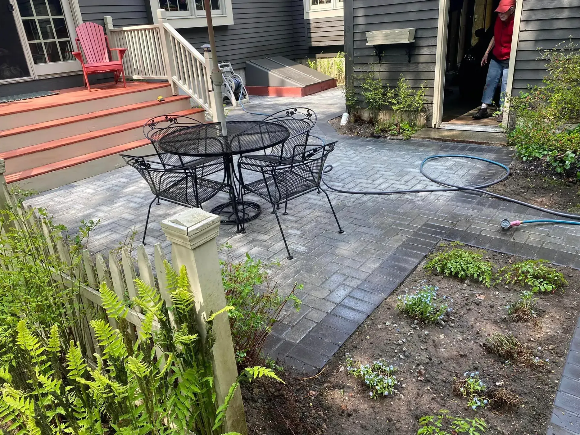 A patio with a table and chairs in front of a house.
