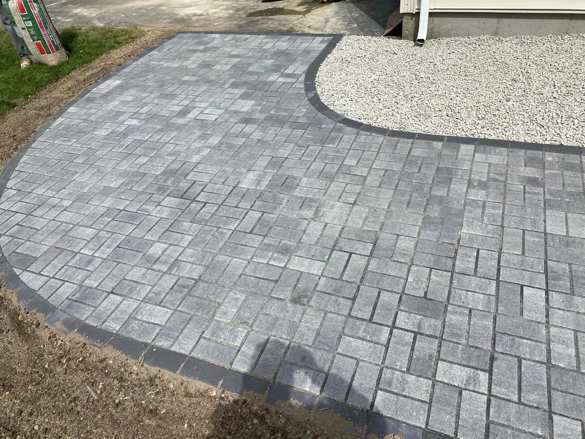 A brick walkway is being built in front of a house.